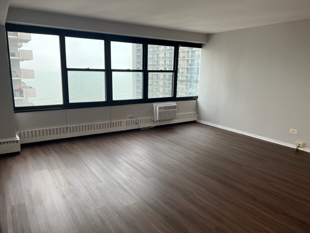 6030 North Sheridan Road, Unit 1712 Chicago, IL 60660 - Photo 9 of 28 a view of an empty room with wooden floor and a window