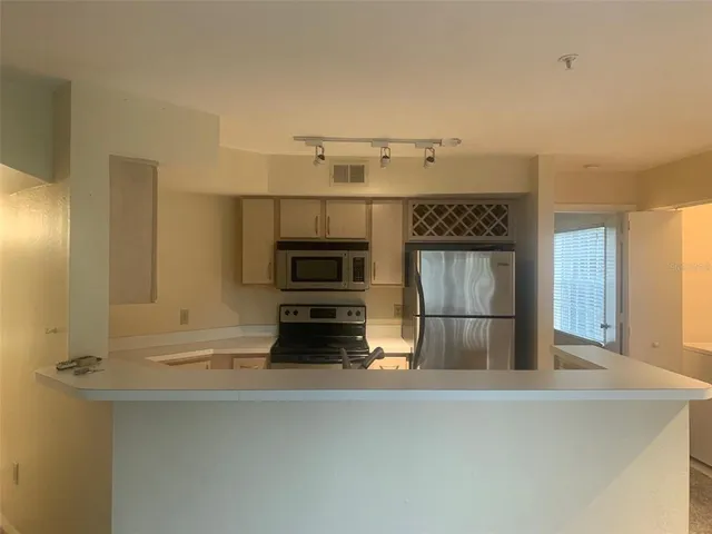 a kitchen with a refrigerator and a stove top oven