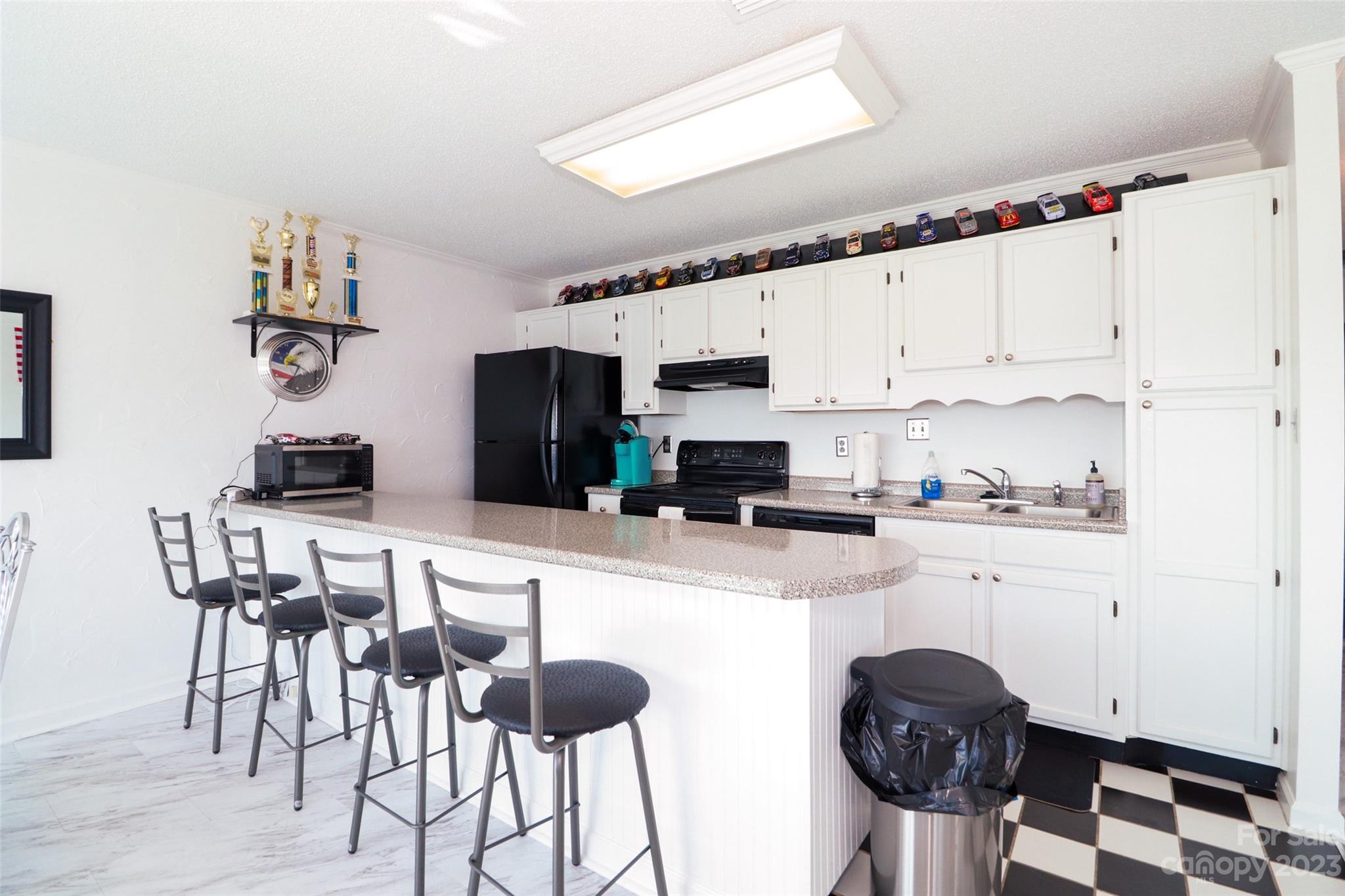 4721 Morehead Road, Unit 204 Concord, NC 28027 - Photo 11 of 19 a kitchen with stainless steel appliances a stove a refrigerator and white cabinets with wooden floor