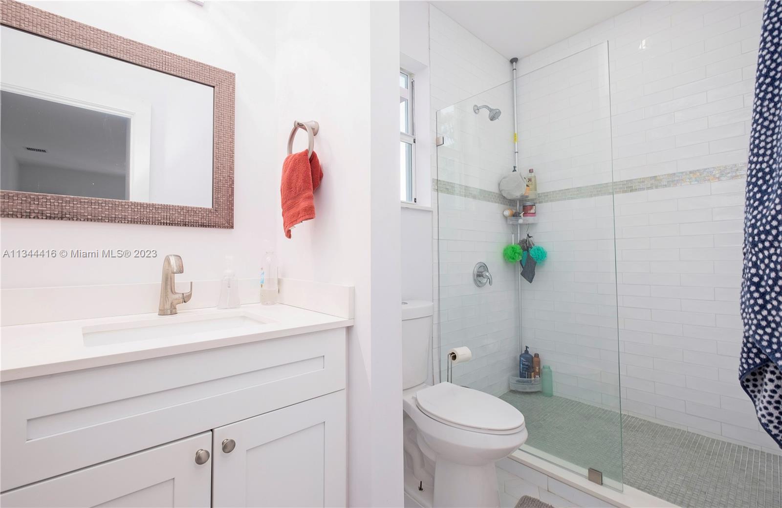 2734 Southwest 26th Street, Unit 2734 Miami, FL 33133 - Photo 18 of 41 a bathroom with a sink a toilet and a mirror