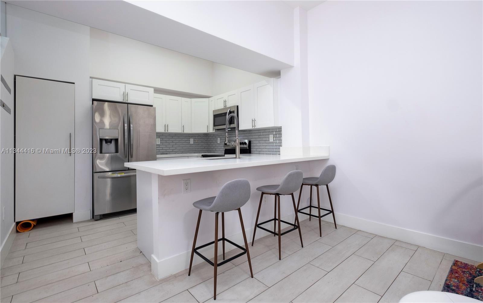 2734 Southwest 26th Street, Unit 2734 Miami, FL 33133 - Photo 7 of 41 a kitchen with stainless steel appliances a sink cabinets and a refrigerator