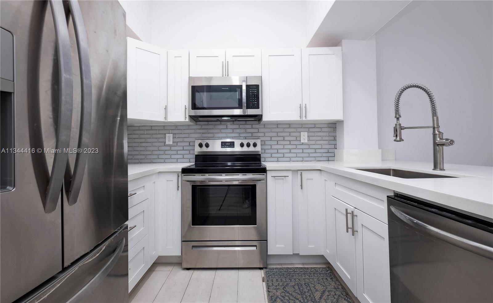 2734 Southwest 26th Street, Unit 2734 Miami, FL 33133 - Photo 8 of 41 a kitchen with white cabinets stainless steel appliances and a counter space