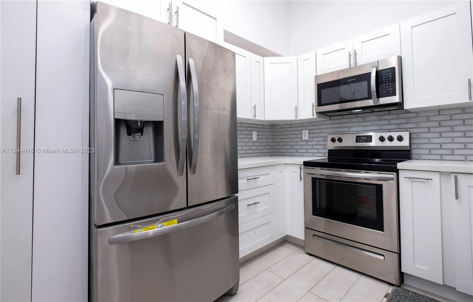2734 Southwest 26th Street, Unit 2734 Miami, FL 33133 - Photo 9 of 41 a kitchen with stainless steel appliances a stove a microwave and a refrigerator