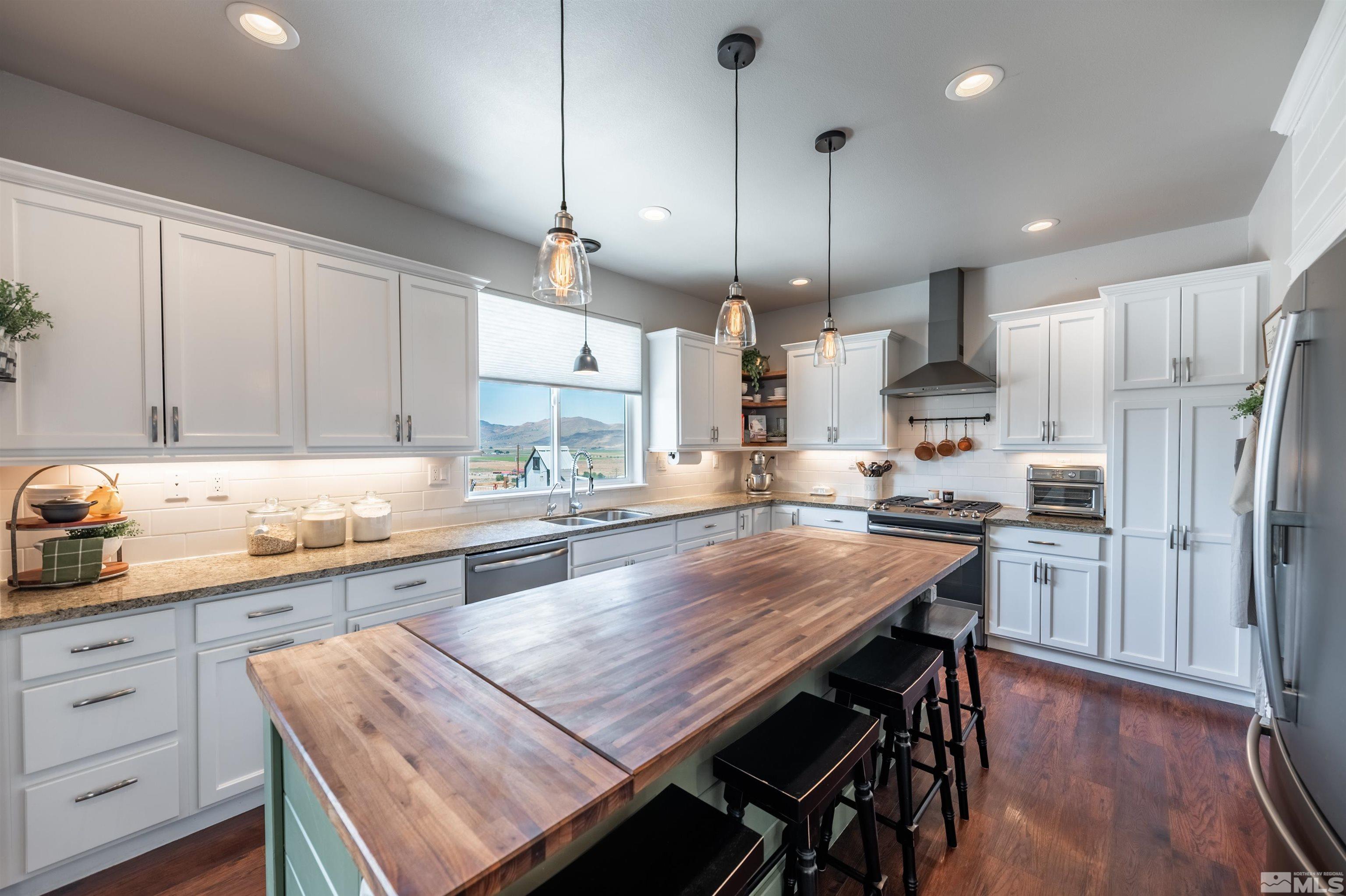 205 Bootstrap Lane Reno, NV 89510 - Photo 11 of 39 a kitchen with granite countertop a table chairs stainless steel appliances and cabinets