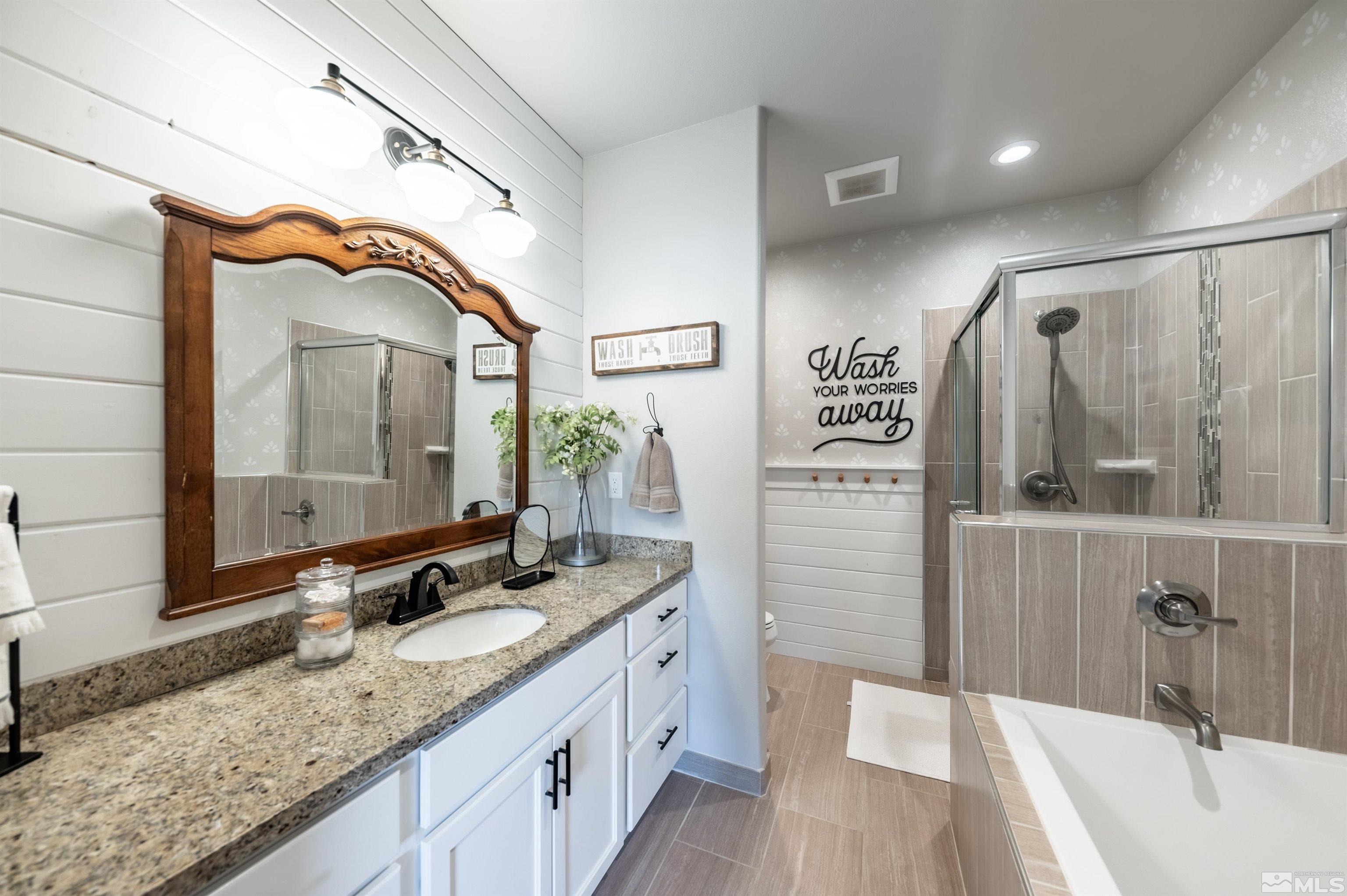 205 Bootstrap Lane Reno, NV 89510 - Photo 17 of 39 a bathroom with a granite countertop sink a mirror a vanity and shower
