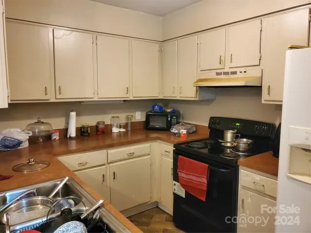 a kitchen with a sink a stove and cabinets