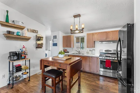 a kitchen with stainless steel appliances granite countertop a sink dishwasher and cabinets with wooden floor