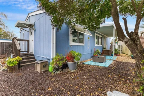 a view of a house with backyard and sitting area