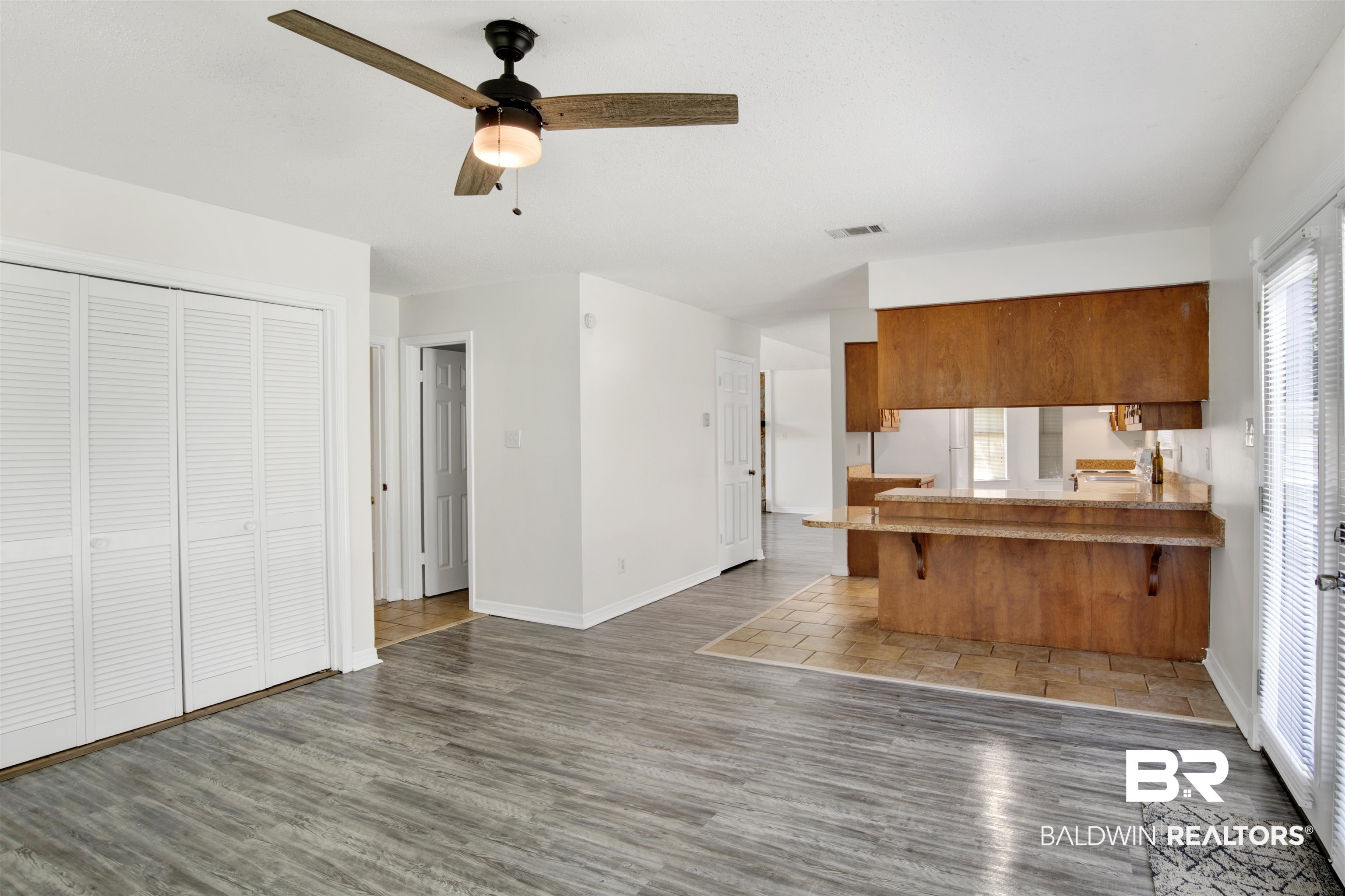 5480 Country Club Boulevard Theodore, AL 36582 - Photo 16 of 36 Kitchen with dark hardwood / wood-style flooring, kitchen peninsula, ceiling fan, and a breakfast bar area
