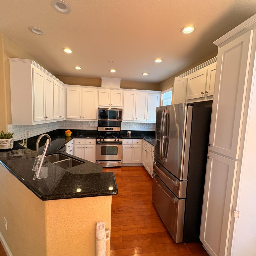 7969 Kipling Circle Gilroy, CA 95020 - Photo 5 of 19 a kitchen with granite countertop a refrigerator a sink a stove top oven and cabinets
