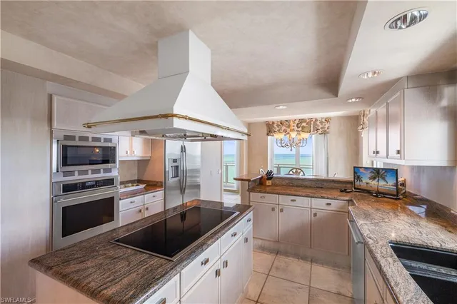 a kitchen with stainless steel appliances kitchen island granite countertop a sink and a stove