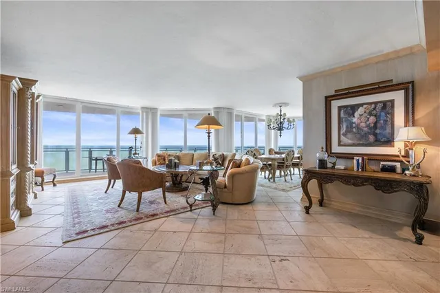 a living room with couches a coffee table and a dining table with kitchen view