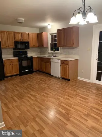 a kitchen with stainless steel appliances kitchen island granite countertop a stove a sink and a refrigerator