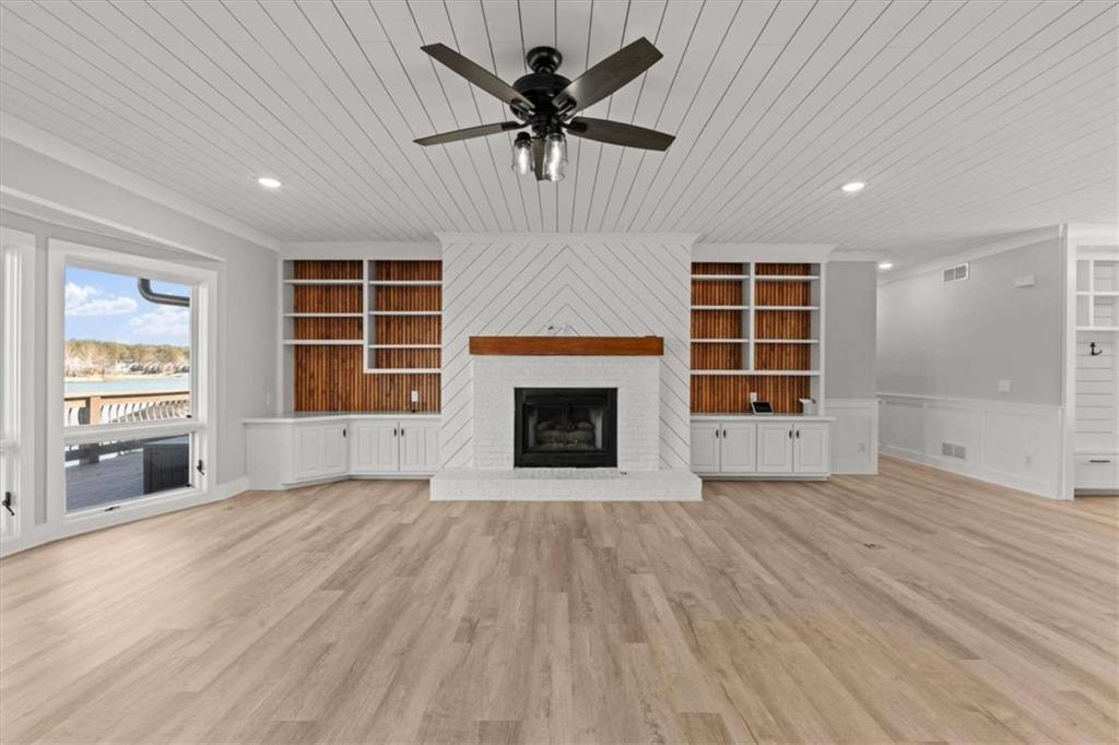 1127 Lakeshore Court Villa Rica, GA 30180 - Photo 13 of 86 an empty room with windows a fireplace a ceiling fan and windows