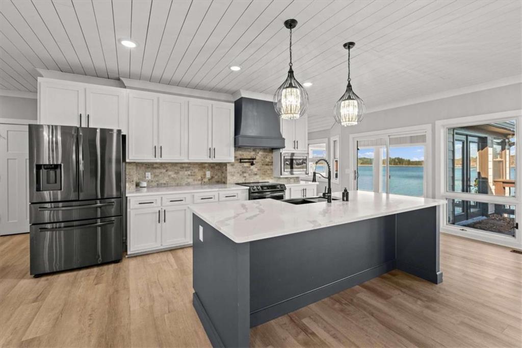 1127 Lakeshore Court Villa Rica, GA 30180 - Photo 19 of 86 a kitchen with stainless steel appliances kitchen island granite countertop a refrigerator a sink dishwasher a stove and white cabinets with wooden floor
