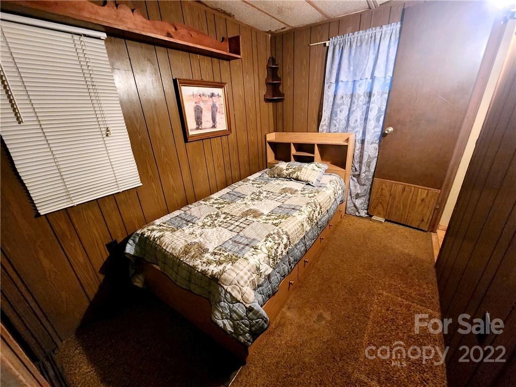 541 Incinerator Road Clyde, NC 28721 - Photo 5 of 11 a bedroom with a bed and a mirror