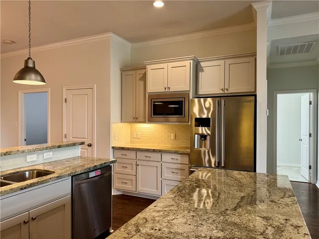 a kitchen with stainless steel appliances granite countertop a sink refrigerator and cabinets
