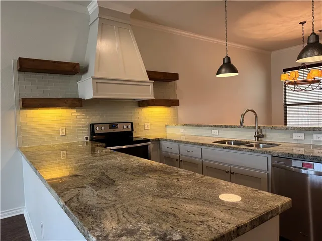 a kitchen with sink stove and cabinets