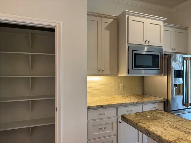 a kitchen with granite countertop a stove and a microwave