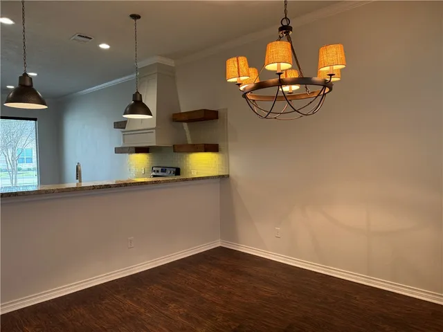 a view of a living room with wooden floor and windows