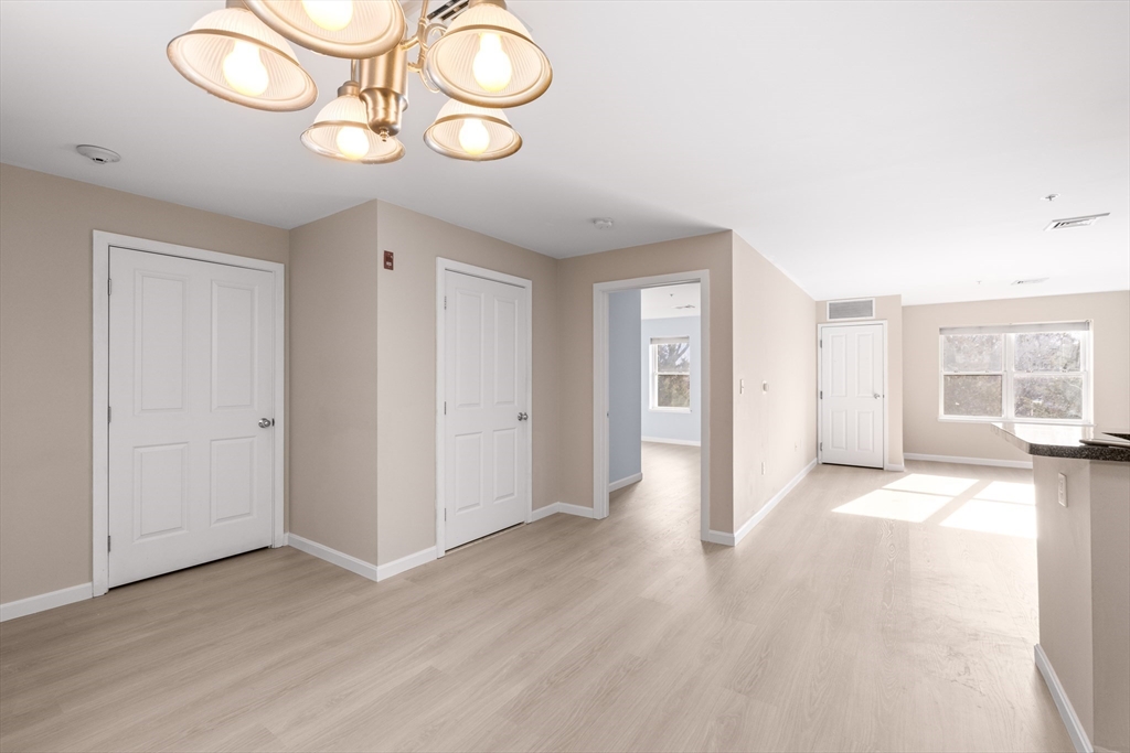 30 Franklin Street, Unit 314 Malden, MA 02148 - Photo 8 of 28 an empty room with wooden floor and windows