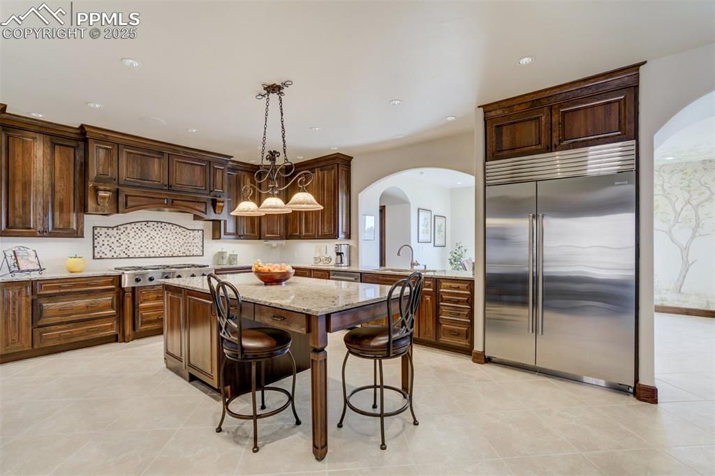 14250 Aiken Ride View Colorado Springs, CO 80926 - Photo 18 of 50 a kitchen with stainless steel appliances granite countertop a stove top oven a refrigerator a sink and dishwasher
