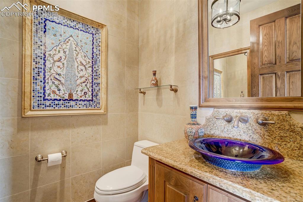 14250 Aiken Ride View Colorado Springs, CO 80926 - Photo 29 of 50 a bathroom with a granite countertop toilet sink and mirror