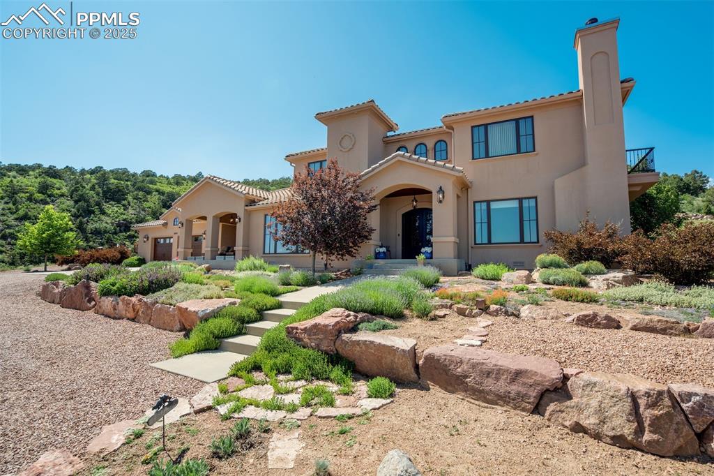 14250 Aiken Ride View Colorado Springs, CO 80926 - Photo 3 of 50 a front view of a house with a yard and potted plants