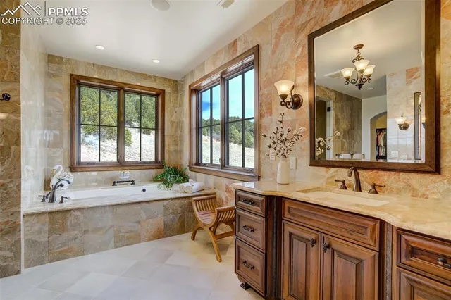 a spacious bathroom with a double vanity sink a large mirror a bathtub and next to a window