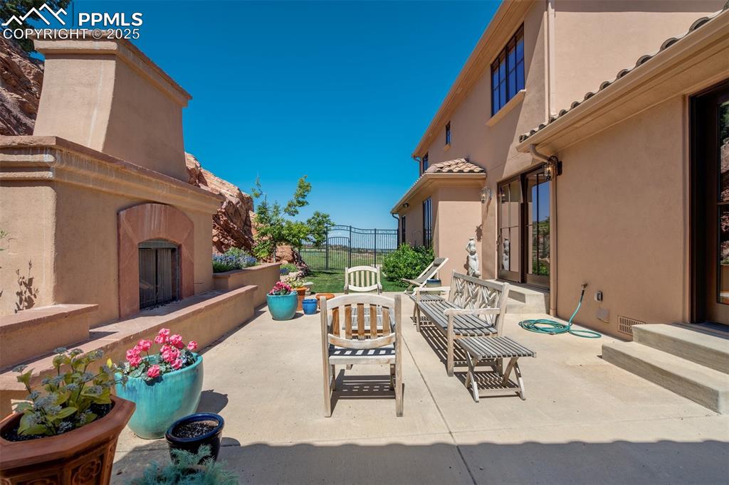 14250 Aiken Ride View Colorado Springs, CO 80926 - Photo 43 of 50 a view of a patio with couches table and chairs potted plants