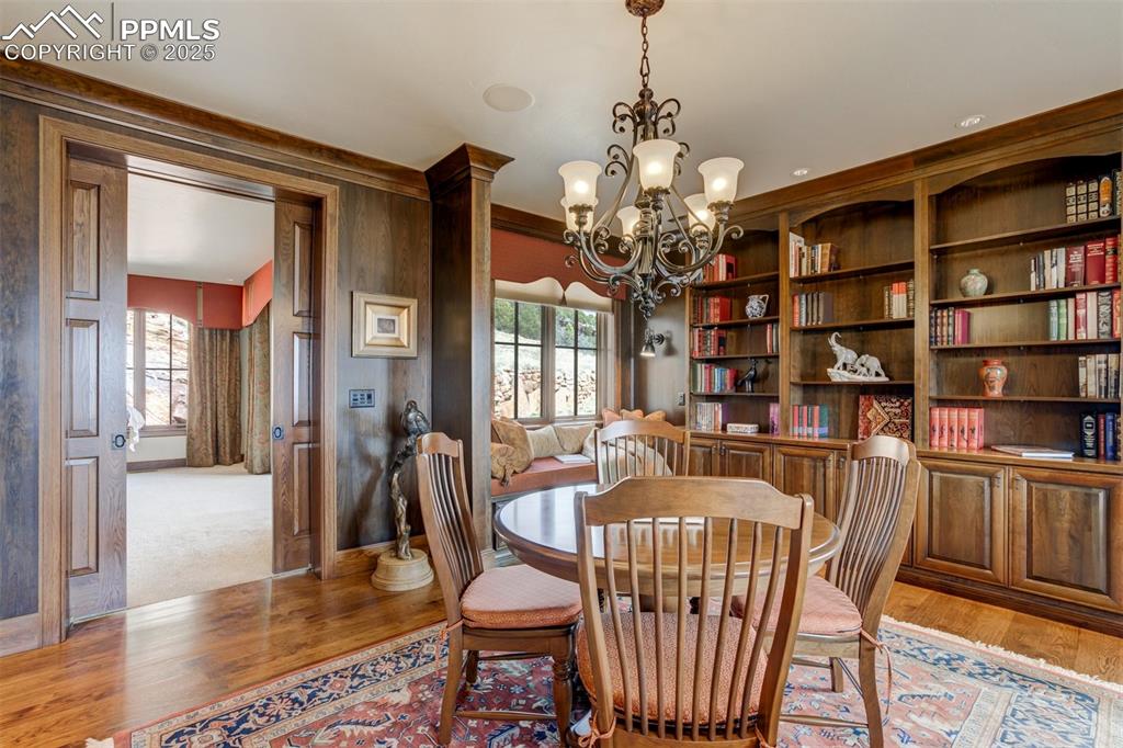 14250 Aiken Ride View Colorado Springs, CO 80926 - Photo 9 of 50 a dining room with furniture a chandelier and wooden floor