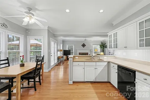 a large white kitchen with lots of counter top space and stainless steel appliances