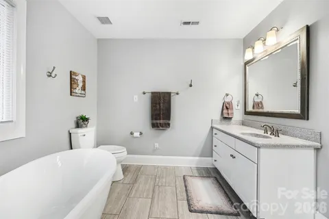 a bathroom with a tub sink and mirror