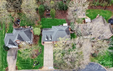 an aerial view of a house with a yard and large tree