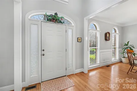 an entryway with wooden floor and windows