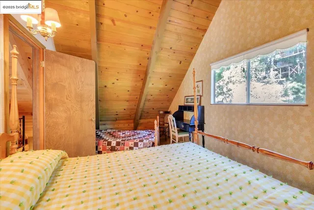 a bedroom with a bed and a flat tv screen on dresser