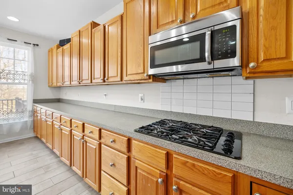 a kitchen with wooden cabinets and a stove top oven