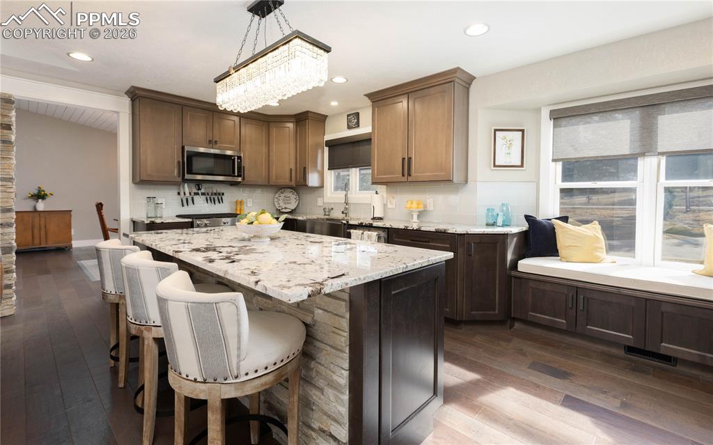17840 New London Road Monument, CO 80132 - Photo 5 of 38 Beautiful light fixtures, island and window seat in kitchen