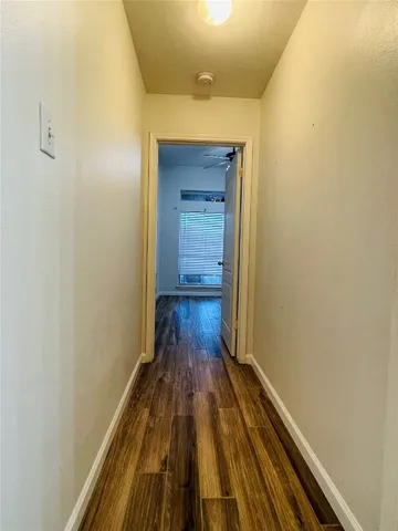 a view of a hallway with wooden floor and a hallway