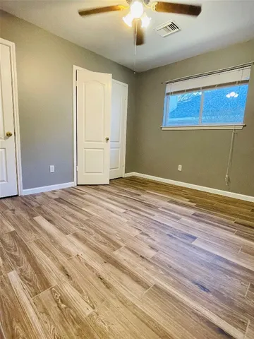 a view of a room with wooden floor and white walls