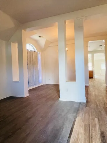 a view of an empty room with wooden floor