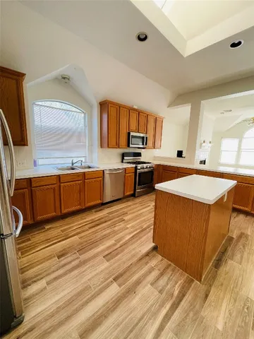 a large kitchen with stainless steel appliances granite countertop a sink and cabinets