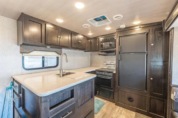 a kitchen with a refrigerator sink and cabinets