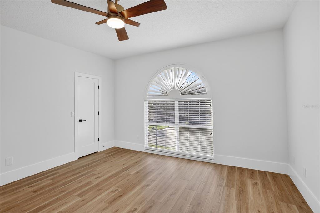 1815 Seneca Boulevard Winter Springs, FL 32708 - Photo 21 of 32 an empty room with wooden floor chandelier fan and windows