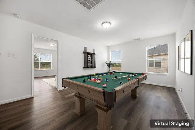 a room with pool table and windows