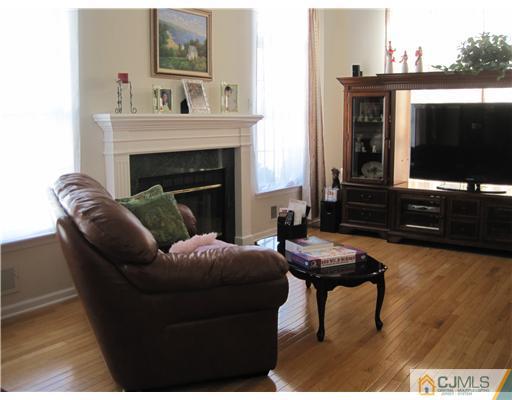 31 Lexington Road Monmouth Junction, NJ 08852 - Photo 6 of 12 a living room with furniture a flat screen tv and a fireplace
