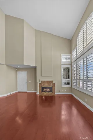 a view of an empty room with a fireplace and a window