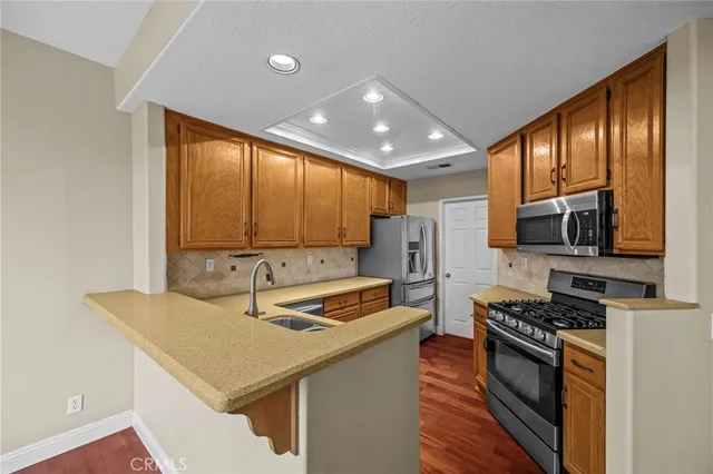 a kitchen with stainless steel appliances a sink stove and refrigerator