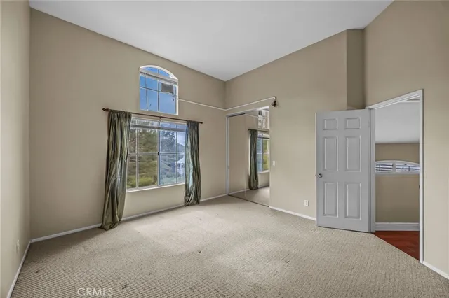 a view of an empty room with glass door and a cabinet