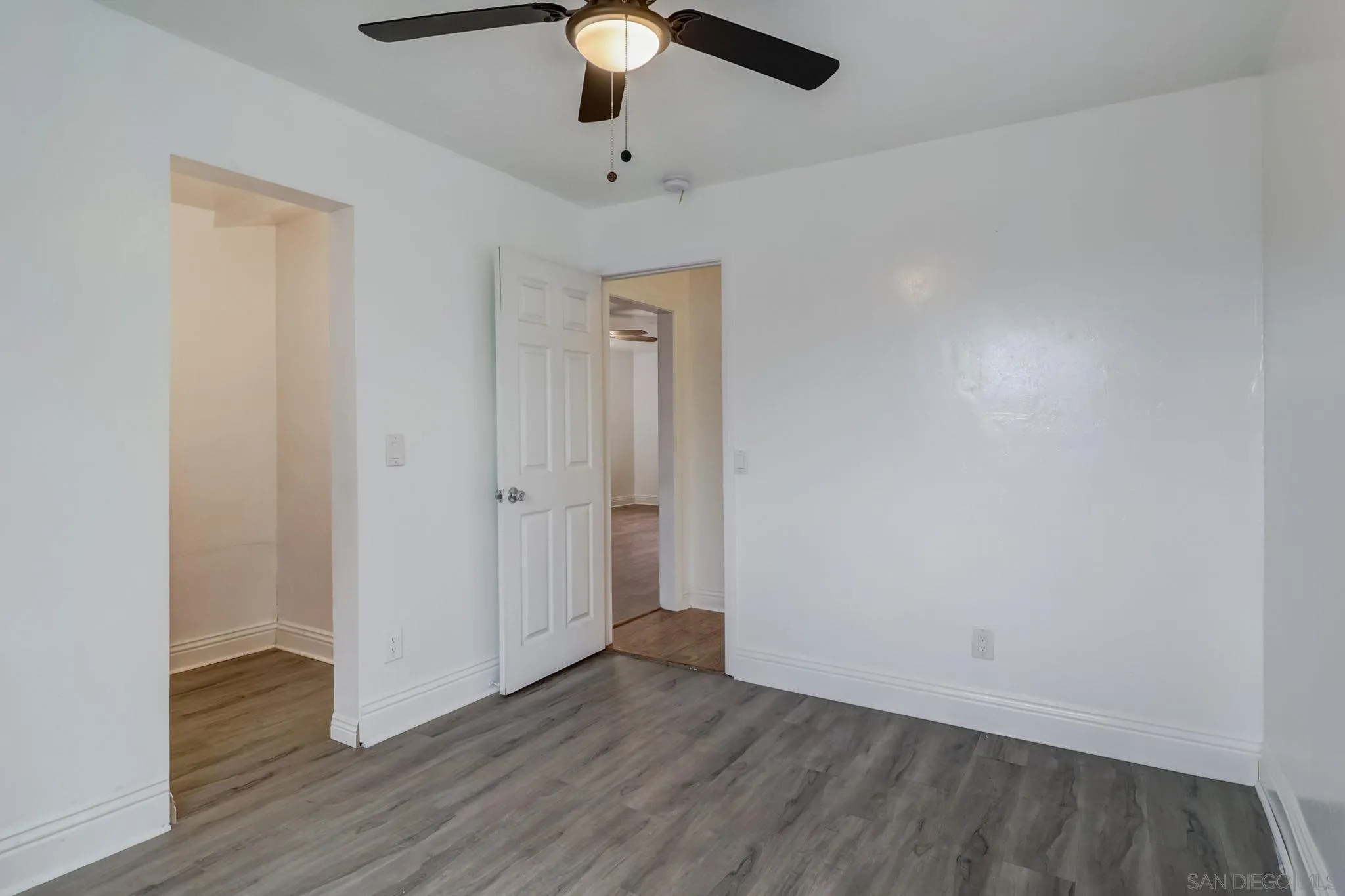9115 Rosedale Drive Spring Valley, CA 91977 - Photo 20 of 31 an empty room with wooden floor chandelier fan and closet area